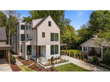 Modern two-story home featuring a unique design with large windows and beautifully landscaped front yard at 339 1/2 Mulberry St, Raleigh, NC 27604