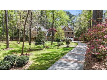 Charming two-story brick home with a lush green lawn and mature trees at 5317 Burning Oak Ct, Raleigh, NC 27606