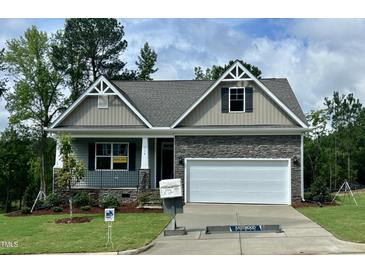 Charming single-story home with stone accents, well-manicured lawn, and inviting curb appeal at 114 Arundel Dr, Archer Lodge, NC 27527