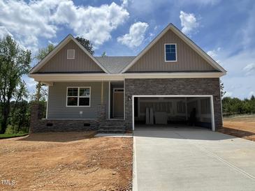Charming new construction home featuring stone accents, a two-car garage, and a welcoming covered front porch at 114 Arundel Dr, Archer Lodge, NC 27527