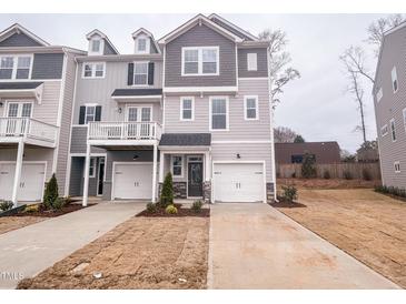 New construction townhome with a one car garage and gray wood siding at 203 Pond Vw Ct # 1, Fuquay Varina, NC 27526