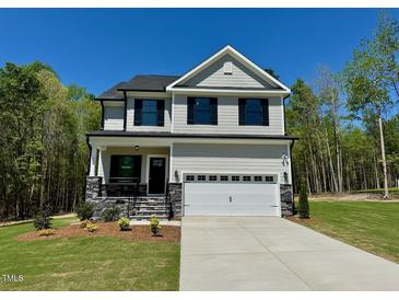 Charming two-story home with a well-manicured lawn and a two-car garage at 262 Grand Griffon Way, Lillington, NC 27546