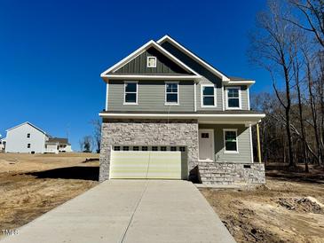 Two-story house with gray siding, stone accents, and a two-car garage at 45 Covey Rise Way, Lillington, NC 27546