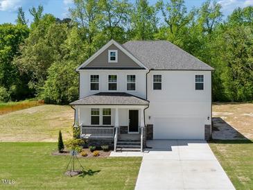 Charming two-story home boasts a well-maintained lawn and inviting front porch at 63 Whimbrel Ct, Lillington, NC 27546