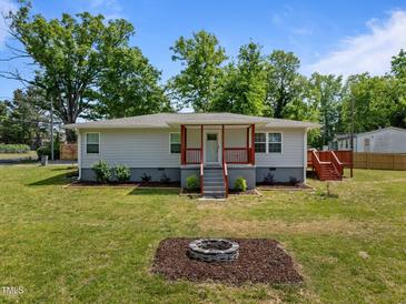 Charming single-story home with a cozy front porch and a welcoming fire pit area, perfect for outdoor gatherings at 670 Mcadams Rd, Hillsborough, NC 27278