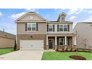 Charming two-story home featuring a brick and siding exterior with a two-car garage at 107 Ethel Ln, Angier, NC 27501