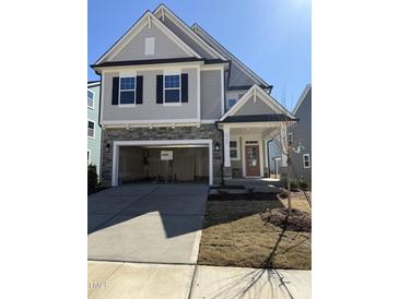 Charming two-story home featuring stone accents, a two-car garage, and a welcoming front porch at 2391 Englemann Dr Dr # 124, Apex, NC 27502