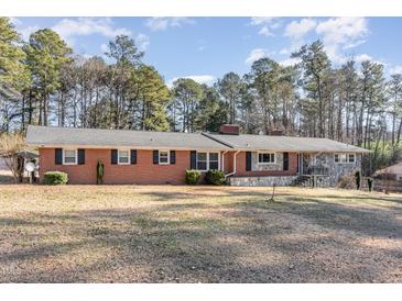 Brick ranch house with stone accents, large yard, and mature trees at 129 Jeffress Dr, Louisburg, NC 27549
