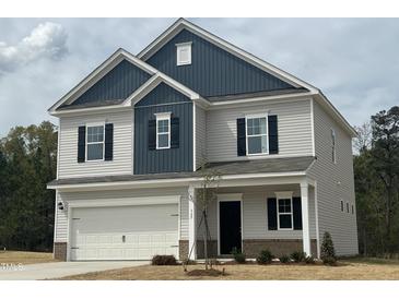 Charming two-story home with blue and grey siding and an attached two car garage at 165 Knoll Way, Sanford, NC 27332