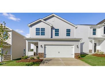 Beautiful two-story home featuring a two car garage, architectural shingles, and professionally designed landscape at 262 Moore Creek Dr, Fuquay Varina, NC 27526