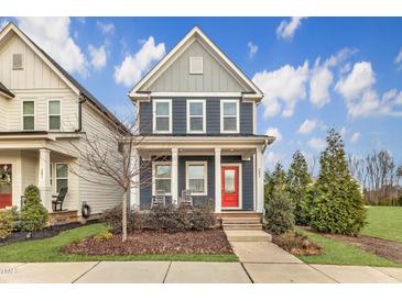 Charming two-story home featuring a welcoming red front door, cozy front porch, and manicured landscaping at 283 Daniel Ridge Rd, Wendell, NC 27591