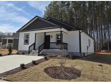 Charming single-story home featuring white siding, black trim, and a cozy front porch at 4553 Dedication Dr, Raleigh, NC 27610