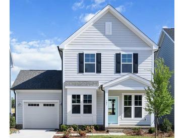 Charming two-story home with light gray siding, black shutters and a cute light blue front door at 85 Windchime Ct, Fuquay Varina, NC 27526