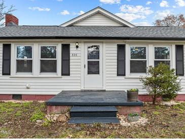 Charming home featuring a quaint front entry, complemented by classic shutters and a well-manicured lawn at 826 Carter Ave, Durham, NC 27703