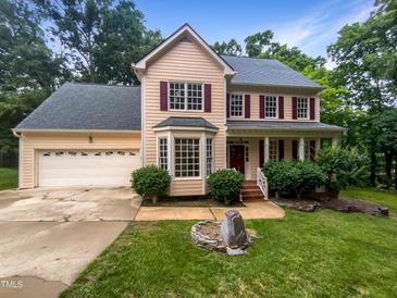 Charming two-story home with a well-manicured lawn, attached garage, and red shutters at 113 Crosswind Dr, Cary, NC 27513