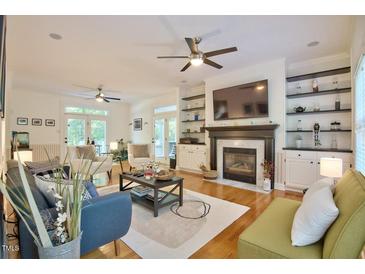 Spacious living room features a fireplace, built-in shelving, and hardwood floors at 340 Andrews Store Rd, Pittsboro, NC 27312