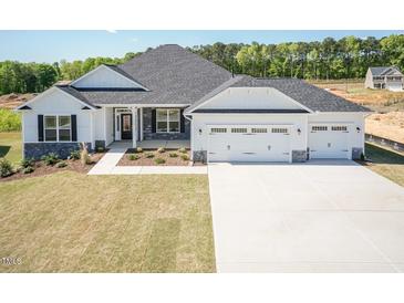 Charming home with a three-car garage, stone accents, and well-maintained landscaping at 534 Glenkirk Pl # 110, Garner, NC 27529