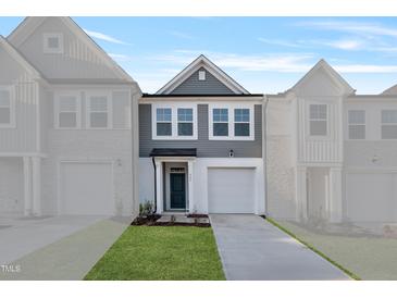 Charming two-story home features a gray exterior, attached garage and manicured lawn at 535 Eversden Dr, Zebulon, NC 27597