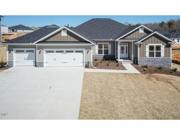 Beautiful single-Gathering home with a three-car garage and stone accents, complemented by a well-manicured front yard at 563 Glenkirk Pl # 104, Garner, NC 27529