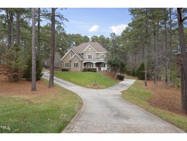 Brick home with 3-car garage and circular driveway. Landscaped yard and mature trees at 1201 Enderbury Dr, Raleigh, NC 27614