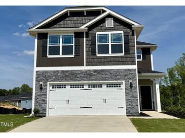 Charming two-story home featuring stone accents, a two-car garage, and classic architectural design at 211 Drayton Hall Ln, Sanford, NC 27330