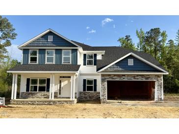Charming two-story home with blue and white siding and a spacious two-car garage at 69 Streamline Ct, Lillington, NC 27546