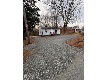 Charming, one-story home with rock-covered yard and covered front porch at 1118 Jackson St, Burlington, NC 27217