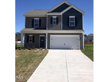 Charming two-story home featuring a two-car garage and a well-manicured front lawn on a sunny day at 120 Vili Dr, Broadway, NC 27505