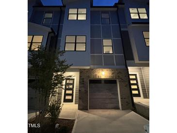 Modern townhome showcasing a two-car garage and sleek, contemporary design at 704 Portia Way, Homesite 15, Morrisville, NC 27560