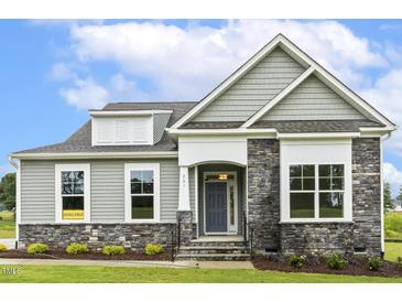 Charming home exterior featuring stone accents, and a well-manicured lawn at 261 Kissington Way, Benson, NC 27504