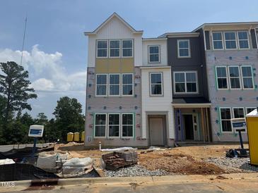 New construction townhouse exterior shows multi-pane windows, partial siding, and brick, with construction materials on the grounds at 303 Chesapeake Cmns St # 99, Garner, NC 27529