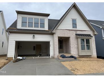 New two-story home featuring white siding, brick accents, and an attached two-car garage at 209 Big Bradley Dr, Wendell, NC 27591