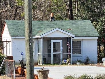 Charming single-story home featuring a cozy screened-in porch and American flag at 2313 Hunter Hill Rd, Rocky Mount, NC 27804