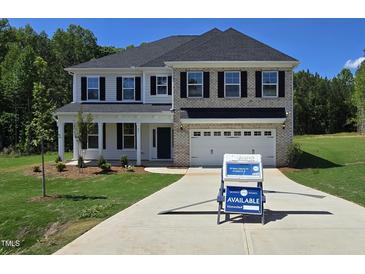 Beautiful new construction home featuring a brick and siding exterior, inviting front porch, and attached two-car garage at 55 New Liberty Dr, Youngsville, NC 27596