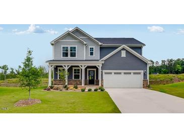 Beautiful two-story home with gray siding, stone accents, well-manicured lawn, and attached two car garage at 630 Contento Ct, Sanford, NC 27330