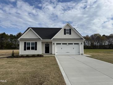 Charming single-story home with a white exterior, black door, and two car garage, set on a sunny lot at 79 Surles Landing Way, Benson, NC 27504