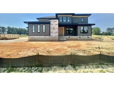 New construction two-story home with gray siding and black trim in a suburban neighborhood at 130 Broadleaf Ln, Louisburg, NC 27549