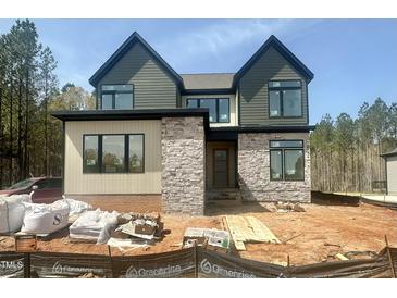 Modern two-story home with mixed siding and stone details, showcasing its contemporary design and curb appeal at 135 Cherry Bark Dr, Youngsville, NC 27596