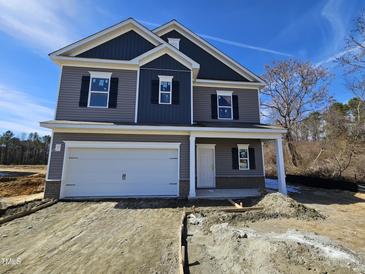 Charming new construction two-story home with gray siding, black shutters, and an attached two car garage at 163 Vili Dr, Broadway, NC 27505