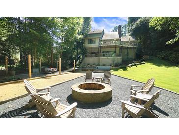 Inviting backyard featuring a fire pit, bocce ball court, and outdoor dining area at 2213 Weybridge Dr, Raleigh, NC 27615