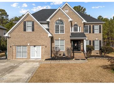 Brick two-story house with a large front yard and attached two-car garage at 5909 Clarks Fork Dr, Raleigh, NC 27616