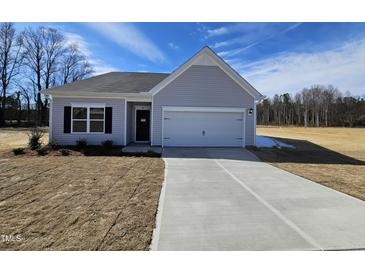 Charming single-story home featuring a attached garage and well-maintained lawn and landscaping at 87 Vili Dr, Broadway, NC 27505