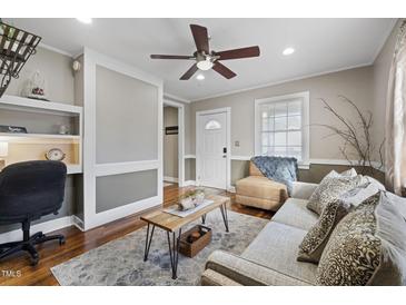 Cozy living room features a comfy couch, wood floors and built-in shelving at 909 E F St, Butner, NC 27509