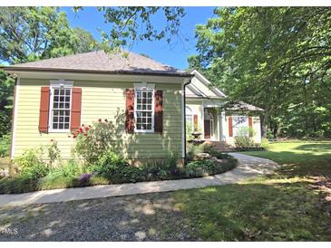 Charming home exterior features red shutters, a well-maintained lawn, and lovely landscaping at 109 Springwood Dr, Wake Forest, NC 27587