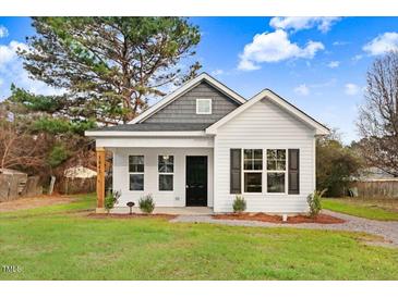 Charming white house with gray roof, landscaping, and a well-maintained lawn at 297 Chartres St, Fuquay Varina, NC 27526