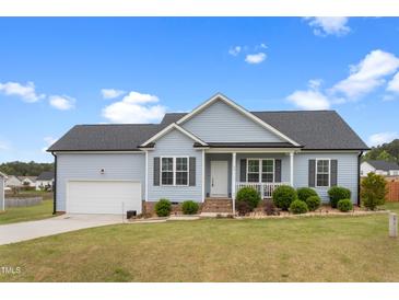 Charming single-story home featuring a well-manicured lawn, attached garage, and inviting front porch at 58 Northview Dr, Middlesex, NC 27557