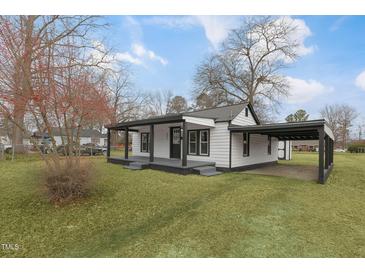 Charming white house with black accents, covered porch, and a well-maintained lawn at 521 Mill St, Smithfield, NC 27577