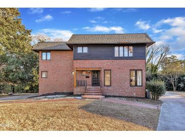 Brick home with a dark trim and a landscaped yard at 126 Person St, Louisburg, NC 27549