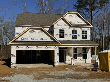 Newly constructed two-story house with attached garage and landscaping at 129 Stallion Way, Benson, NC 27504