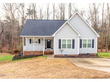 Gray house with black shutters, a covered porch, and a brick foundation at 1610 Rogers Pointe Ln, Creedmoor, NC 27522